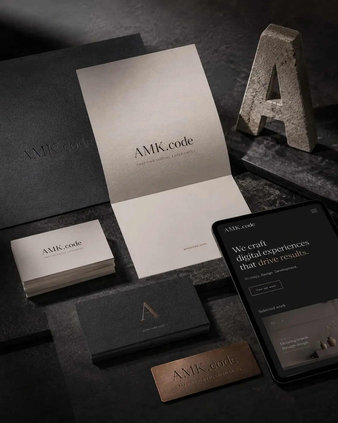 Dark AMK.code brand flat lay on stone